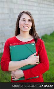 Attractive cool college girl outside with a green folder