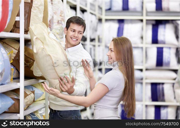 Attractive couple chooses a blanket in the store
