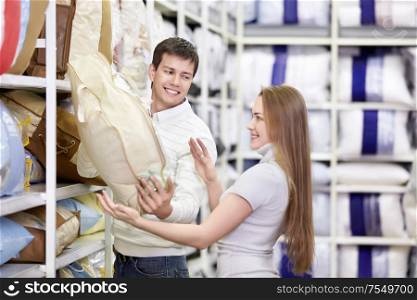 Attractive couple chooses a blanket in the store