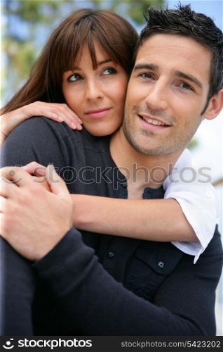 Attractive couple hugging outdoors
