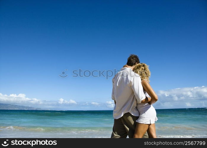 Attractive couple in embrace on Maui, Hawaii beach.