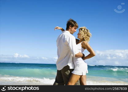 Attractive couple in embrace on Maui, Hawaii beach.