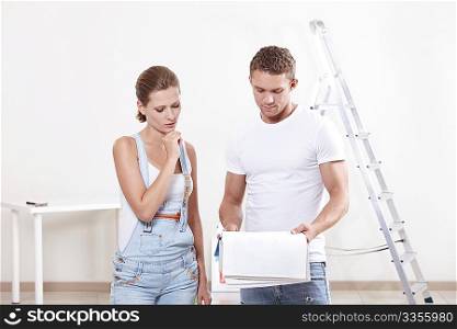 Attractive couple looking at blueprints of the new apartment