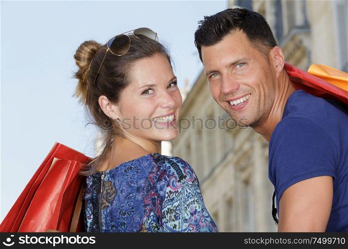 attractive couple looking over the shoulders in a shopping street