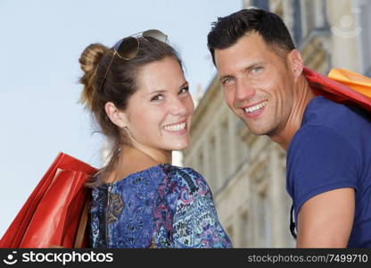 attractive couple looking over the shoulders in a shopping street