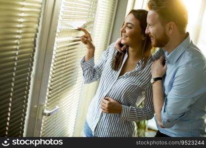 Attractive couple looking trough the room window