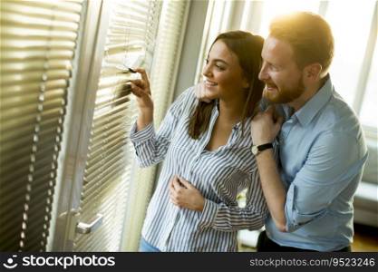 Attractive couple looking trough the room window