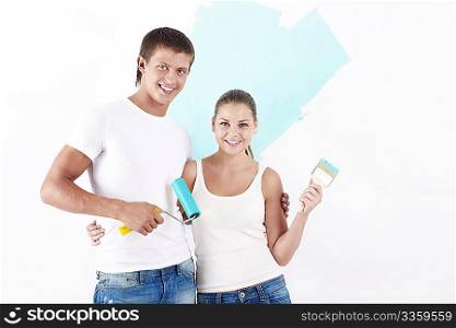 Attractive couple of brushes and rollers on the background of painted wall