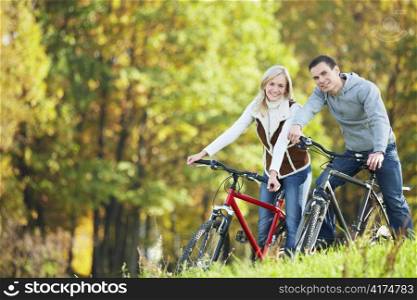 Attractive couple on bicycles in the park