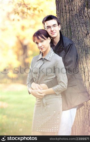 Attractive couple spending sunny day in the autumn park, golden leaves on  background