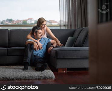 Attractive couple using a laptop in the living room