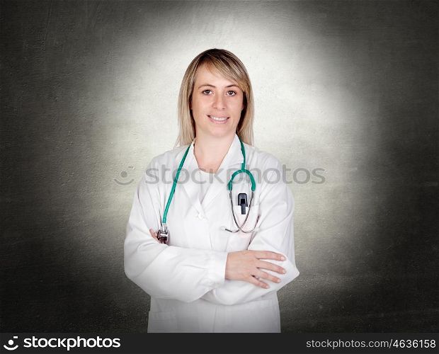 Attractive doctor with blue uniform and a irregular grey background