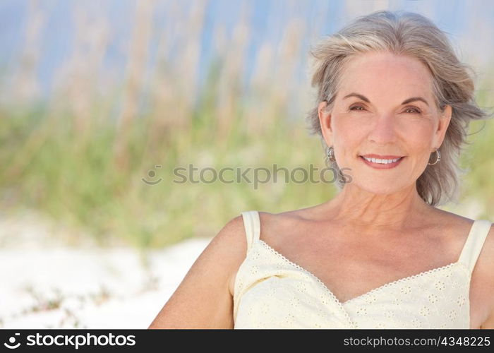 Attractive Elegant Senior Woman Sitting At A Beach