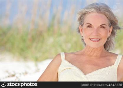 Attractive Elegant Senior Woman Sitting At A Beach
