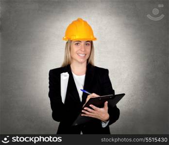 Attractive engineer with clipboard over a irregular grey background