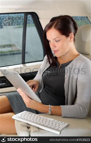 Attractive executive female manager work luxury car touch tablet computer