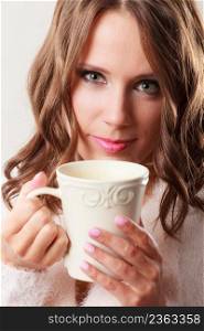 Attractive fall girl long hair holding white mug with coffee warm beverage. Woman warming herself closeup