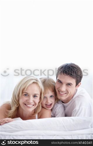 Attractive family with young daughter in the bedroom