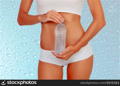 Attractive female body in underwear and water bottle on a wet background with drops