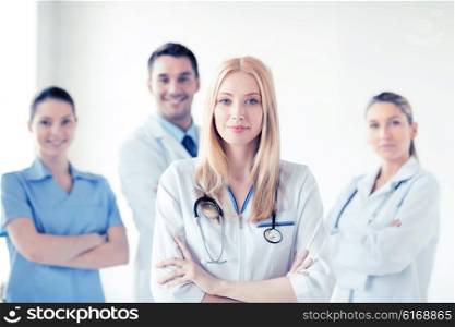 attractive female doctor in front of medical group. female doctor in front of medical group
