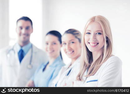 attractive female doctor in front of medical group. female doctor in front of medical group