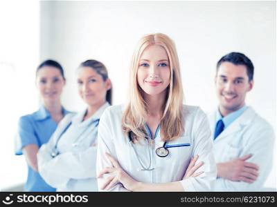 attractive female doctor in front of medical group. female doctor in front of medical group