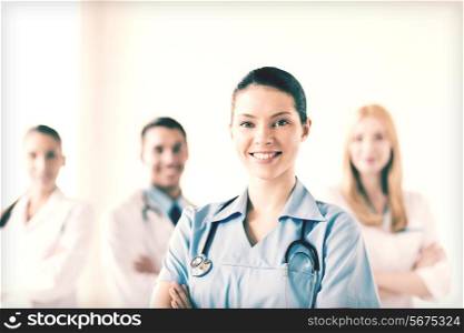 attractive female doctor or nurse in front of medical group