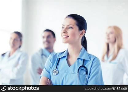 attractive female doctor or nurse in front of medical group. female doctor in front of medical group