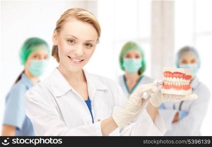 attractive female doctor with toothbrush and jaws in hospital