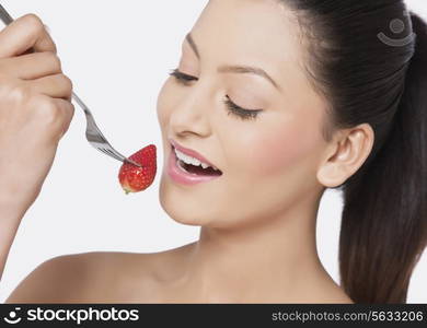 Attractive female eating strawberry