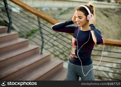 Attractive female  runner taking break after jogging outdoors