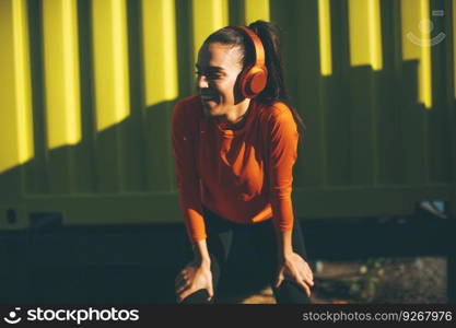 Attractive female runner taking break after jogging outdoors