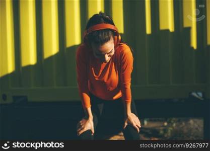 Attractive female runner taking break after jogging outdoors