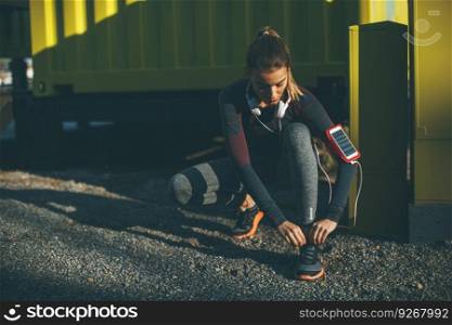 Attractive female  runner taking break after jogging outdoors