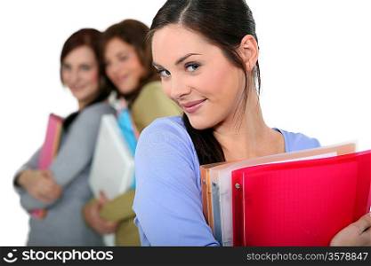 attractive female students holding folders and books