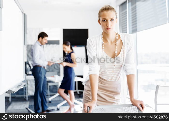 Attractive female worker in office. Attractive female woman in office with colleagues on background