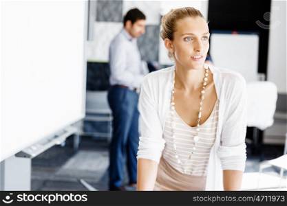 Attractive female worker in office. Attractive female woman in office with colleagues on background