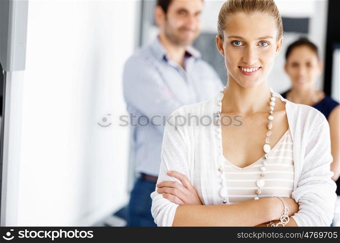 Attractive female worker in office. Attractive female woman in office with colleagues on background
