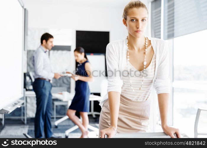 Attractive female worker in office. Attractive female woman in office with colleagues on background