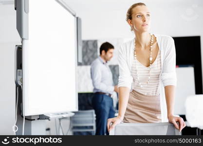 Attractive female worker in office. Attractive female woman in office with colleagues on background