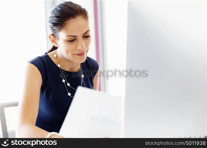 Attractive female worker in office. Attractive female woman in office working with papers