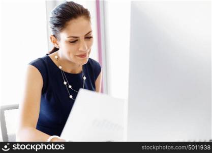 Attractive female worker in office. Attractive female woman in office working with papers