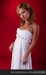Attractive fiancee photo model blond in bridal dress posing - studio shot