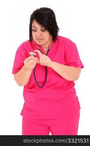 Attractive forty year old over weight nurse in pink scrubs with Stethoscope over white background. Checking to see if stethoscope works.
