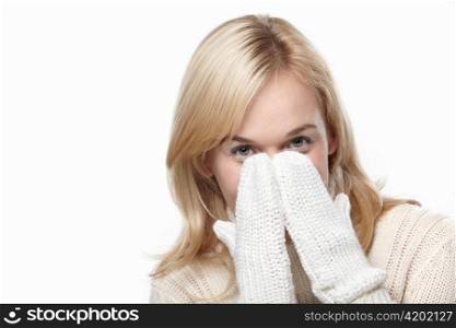 Attractive girl covers her face mittens