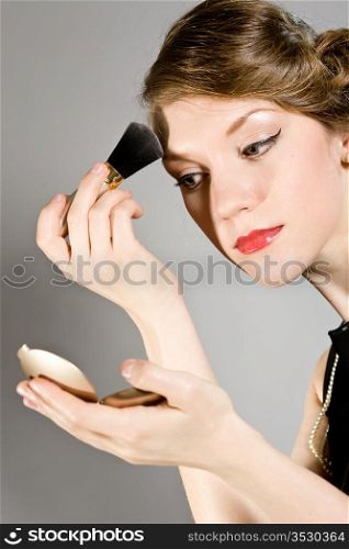 attractive girl does to itself a make-up of the person