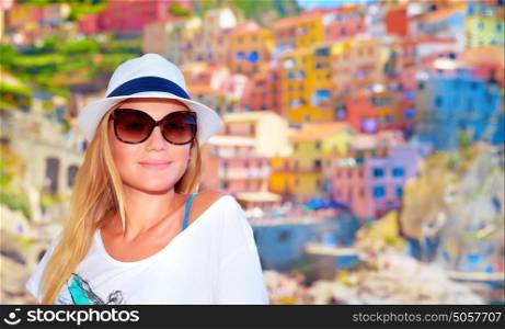 Attractive girl enjoying travel to Europe, standing on wonderful colorful buildings background, famous street in Cinque Terre