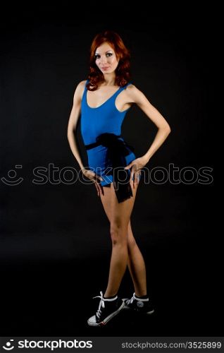 attractive girl in a dark blue short dress and gym shoes