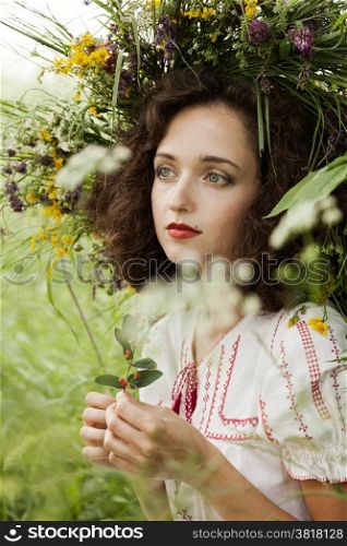 attractive girl in a meadow with a wreath