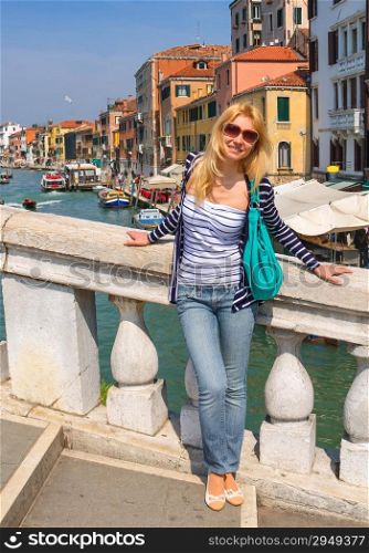 Attractive girl in a sunny day on a bridge in Venice, Italy